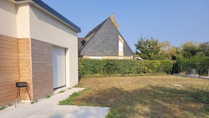 Una casa moderna con un garage, un vialetto asfaltato e un prato curato.
