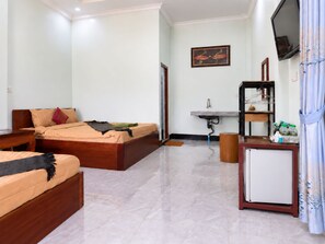 A hotel room with a bed, a small table, a TV, a sink, and a cabinet. - AHHA Bungalow Kampot (Kampot)