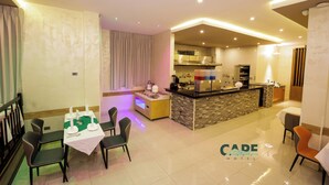 A modern hotel room with a dining area, a kitchen, and a living space. - Cape Hotel (Addis Ababa)