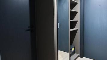 A room with a sliding door closet, a light wooden floor, and a dark wall.