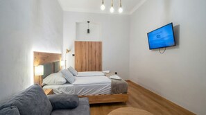 A modern bedroom with a bed, a TV, a wardrobe, and a sofa. - Comfort Flat for 3 Near Lugner City (Vienna)