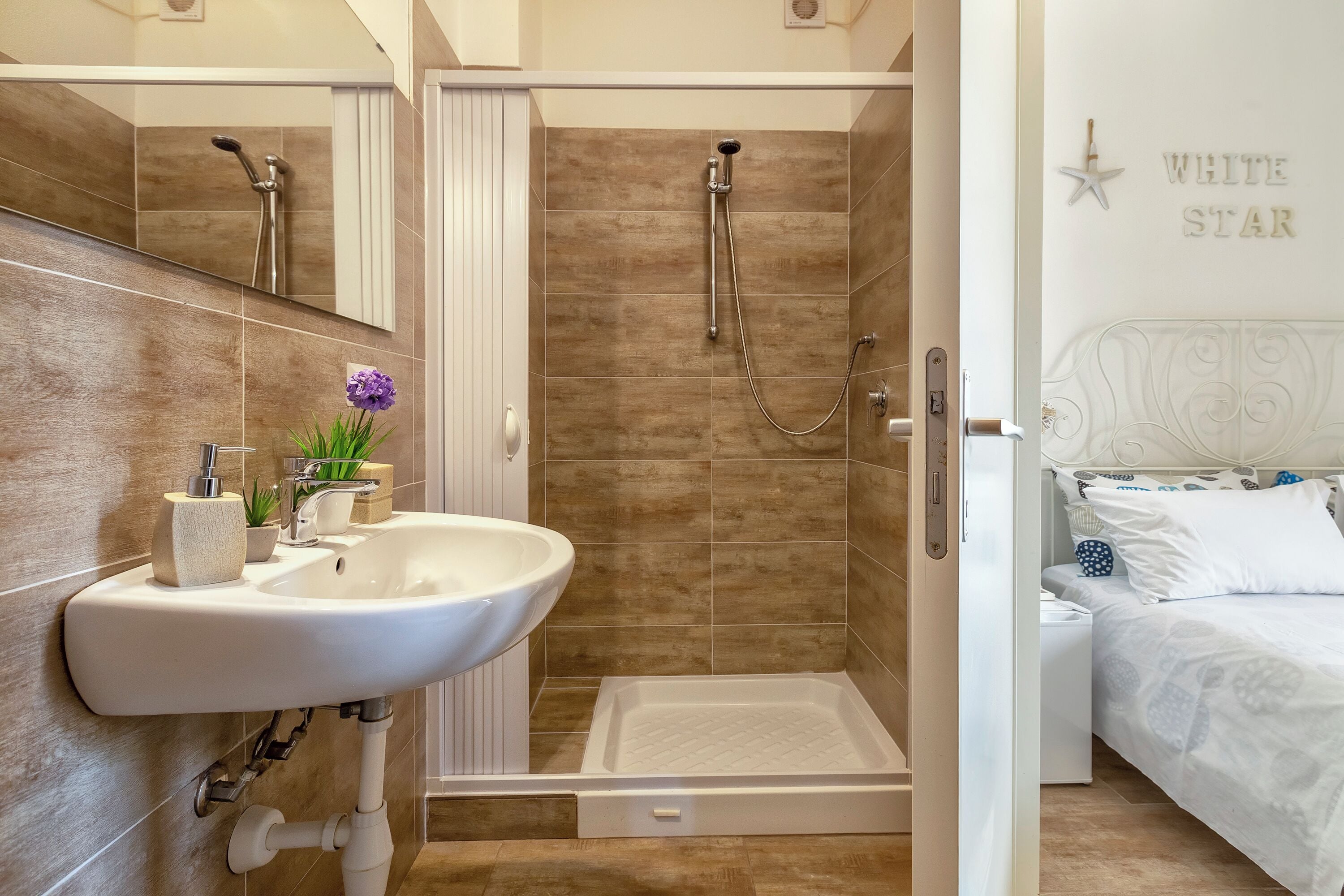 Um banheiro com chuveiro, pia e vaso sanitário.