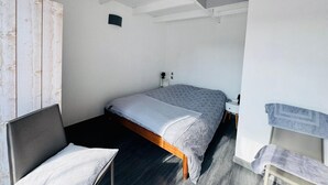 Un dormitorio con cama, mesita de noche y armario.