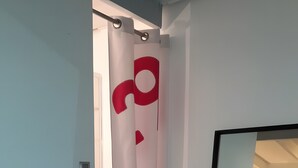 Una habitación moderna con un espejo grande, un banco y una puerta con un diseño rojo.
