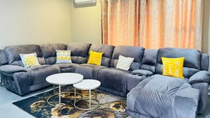 A living room with a sectional sofa, two round coffee tables, and decorative pillows. - The Perazim Place  (Hazyview)
