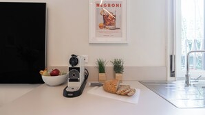A kitchen with a bread slicer, a bowl of fruit, and a poster on the wall. - Italianway Easy - Sebastiano Veniero 27 C - Bilo (Milan)