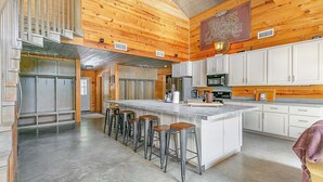 Una cocina amplia con una isla grande, taburetes de bar y un letrero que dice "BRASS LANTERN".
