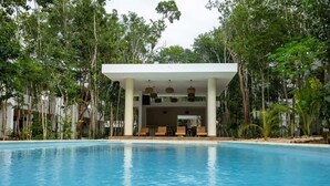 A pool with lounge chairs and a covered seating area surrounded by trees. - AQUA VIVA garden view, Pool, AC, Beach club (Bacalar)