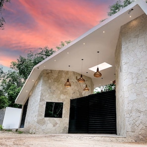 A modern building with a stone facade, a garage door, and hanging pendant lights.