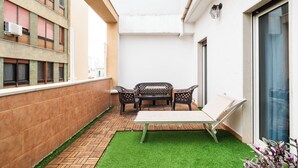 A small outdoor patio with a table and chairs, a small patch of artificial grass, and a brick floor. - Lovely Terrace Apartment by Wonderful Italy (Bari)