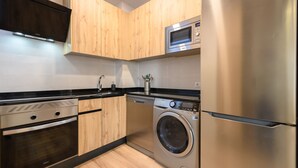 A modern kitchen with stainless steel appliances, wooden cabinets, and a black countertop. - M Car1012 Apartamento con 2 Dormitorios 2 ba o (Madrid)