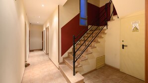 A staircase with a red handrail, beige walls, and a door with a warning sign. - M Car1012 Apartamento con 2 Dormitorios 2 ba o (Madrid)