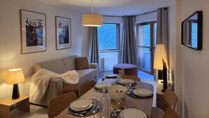 A hotel room with a dining area, a sofa, a coffee table, and a TV. - Apartment 3R, 6 ppl, Valmorel with Parking (Valmorel)