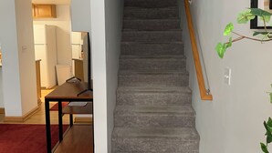 A staircase with a wooden handrail leading to a landing.