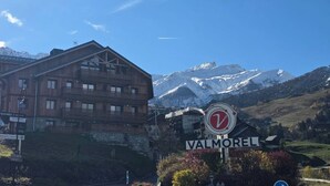 A wooden building with a sign reading "VALMOREL" in front of a mountain backdrop. - 3-Room Apartment in Valmorel - Sleeps 6, Parking (Valmorel)