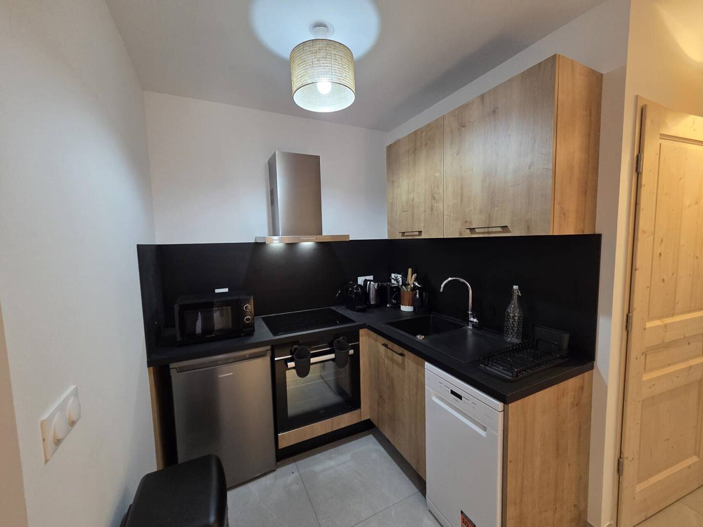 A compact kitchen with a microwave, stove, oven, and dishwasher.