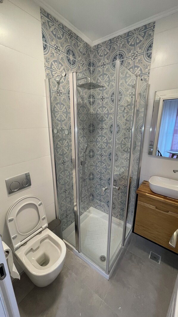 A bathroom with a shower enclosure, a toilet, and a sink. - Jaffa street Studios - 5 min to Market (Jerusalem)