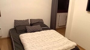 Un dormitorio con cama, almohadas y un radiador.