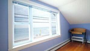 A room with a large window overlooking the ocean, a wooden bench, and a heater under the window. - Ocean views galore. York Beach at your finger tips (York Beach)
