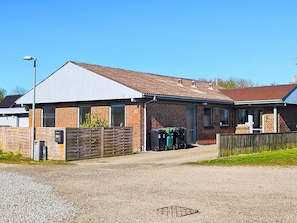 A single-story building with a brick facade, a flat roof, and a covered entrance area.