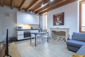 Una sala de estar moderna con chimenea, un comedor y una cocina.