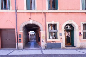 A building with an arched entrance, a visible sign for 'LA BELLEZZA DELL'AMMA,' and a door with a poster. - GuestHost - A splendid 65 sq m apartment, perfect for 4 guests, located on the first floor of a completely renovated period building.The accommodation is located in Valeggio sul Mincio, just an 8-minute walk from the Scaligero Castle, a 15-minute walk fr (Valeggio sul Mincio)