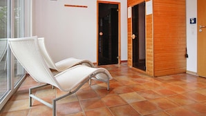 Ein Zimmer mit zwei weißen Korbstühlen, einer Holztür und einem gefliesten Boden.