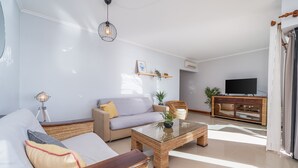 A living room with a sofa, a coffee table, a TV, and a cabinet. - Apartment 'Ocean Horizon House' with Sea View, Wi-Fi and Air Conditioning (Portimão)
