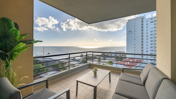 A balcony with a view of the sea, a table, and a sofa. - Apartment 'Ocean Horizon House' with Sea View, Wi-Fi and Air Conditioning (Portimão)