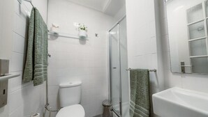 Une salle de bain avec des toilettes, une douche et un lavabo.
