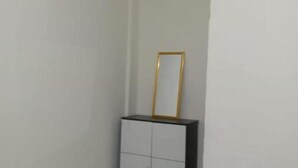 A white cabinet with a gold-framed mirror on top. - Homestay Komodo Mountain View (Batu Cermin)