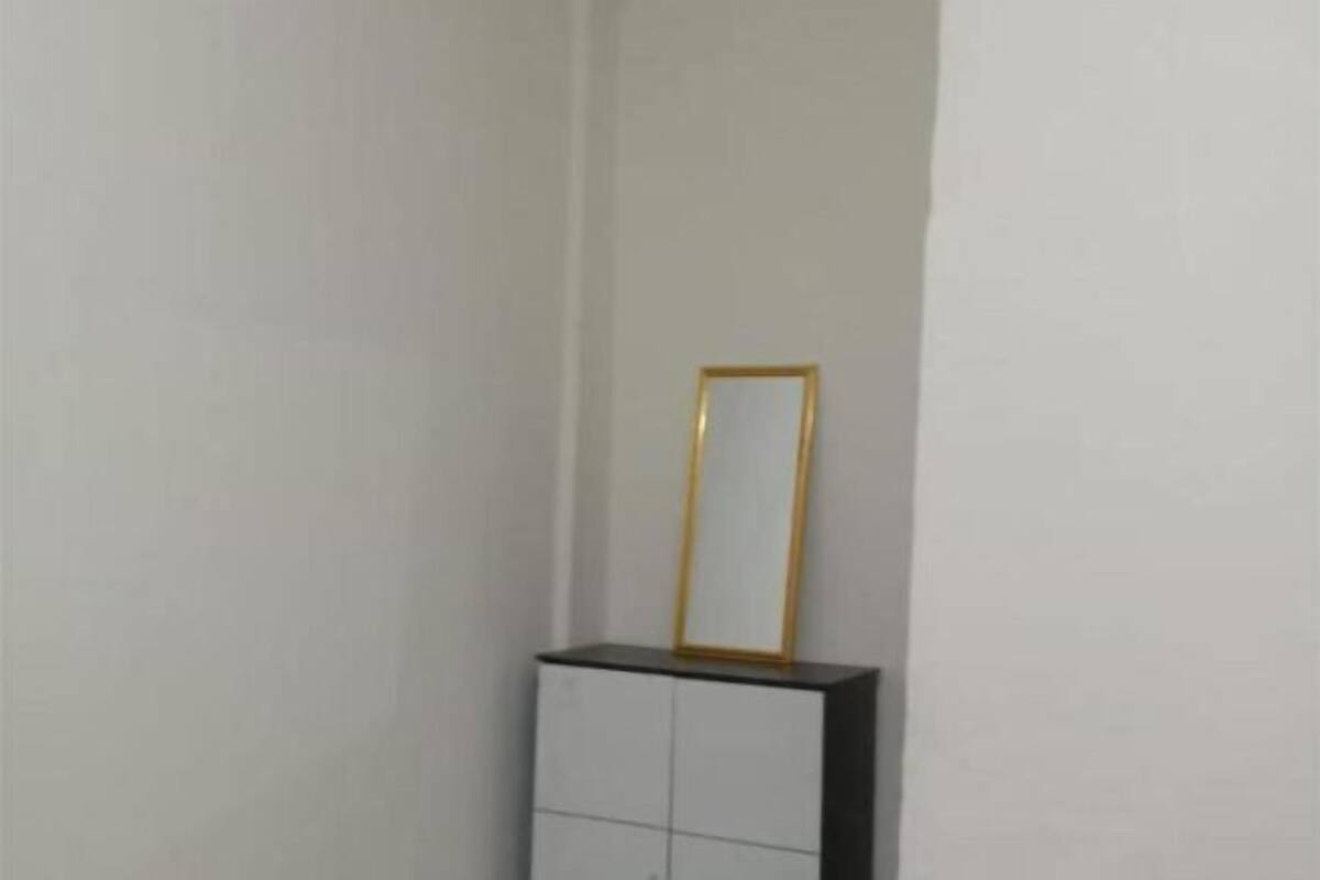 A white cabinet with a gold-framed mirror on top.