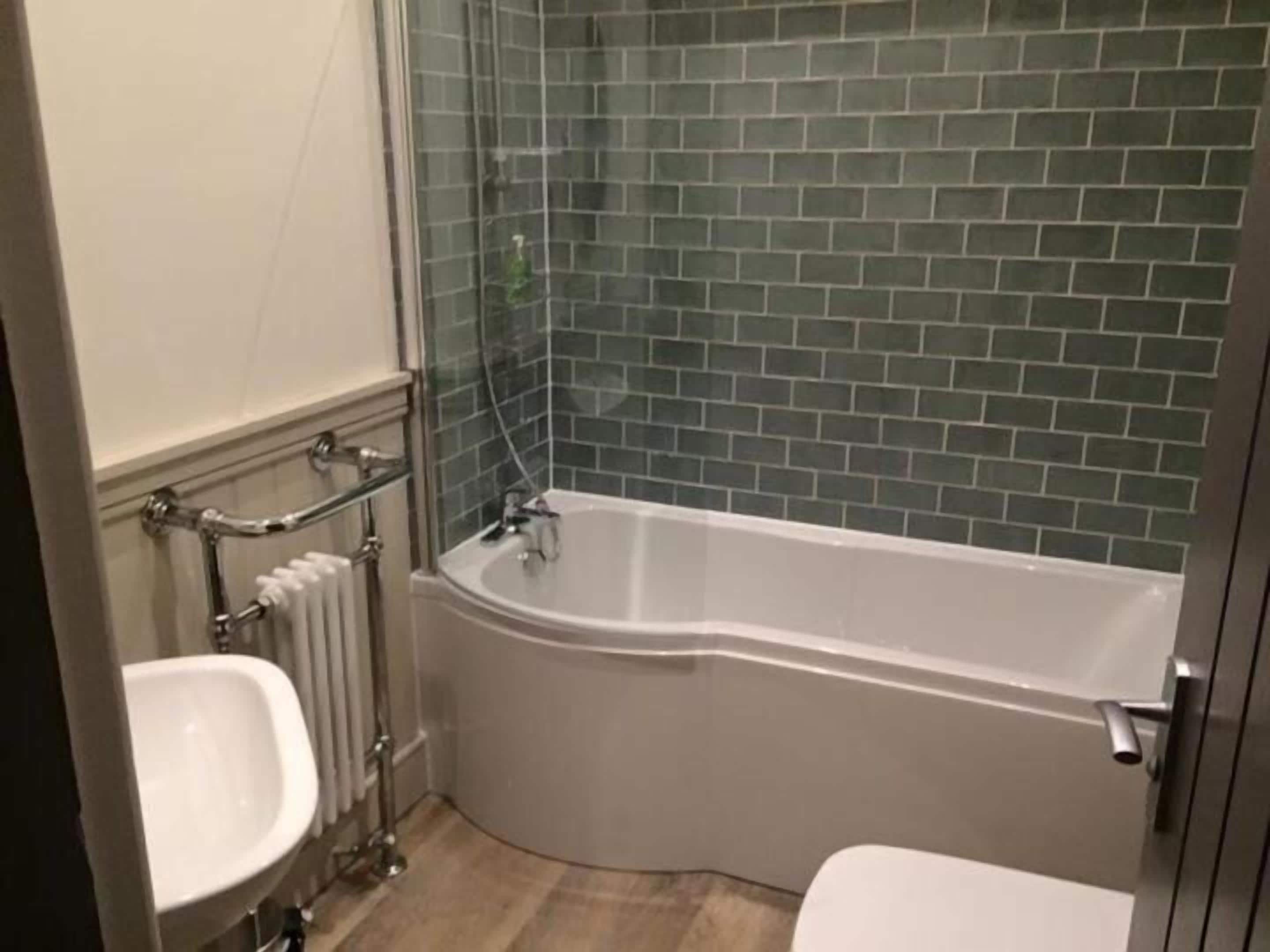 A bathroom with a white bathtub, a white sink, and a toilet.