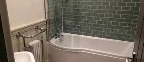 A bathroom with a white bathtub, a white sink, and a toilet.