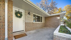 A brick house with a white front door, a welcome mat, and a number plate. - Franklin Heart Homestead – Loveland Family Fun (Loveland)