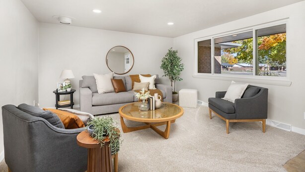 A modern living room with a grey sofa, a round coffee table, and a grey armchair. - Franklin Heart Homestead – Loveland Family Fun (Loveland)