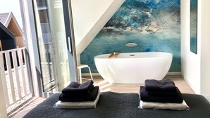 A modern bathroom with a freestanding bathtub, a large window, and a view of the outdoors. - Beautiful Lodge for 5-person Near the Beach (Zoutelande)