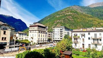 A town with multi-story buildings, a construction site, and a mountain backdrop.