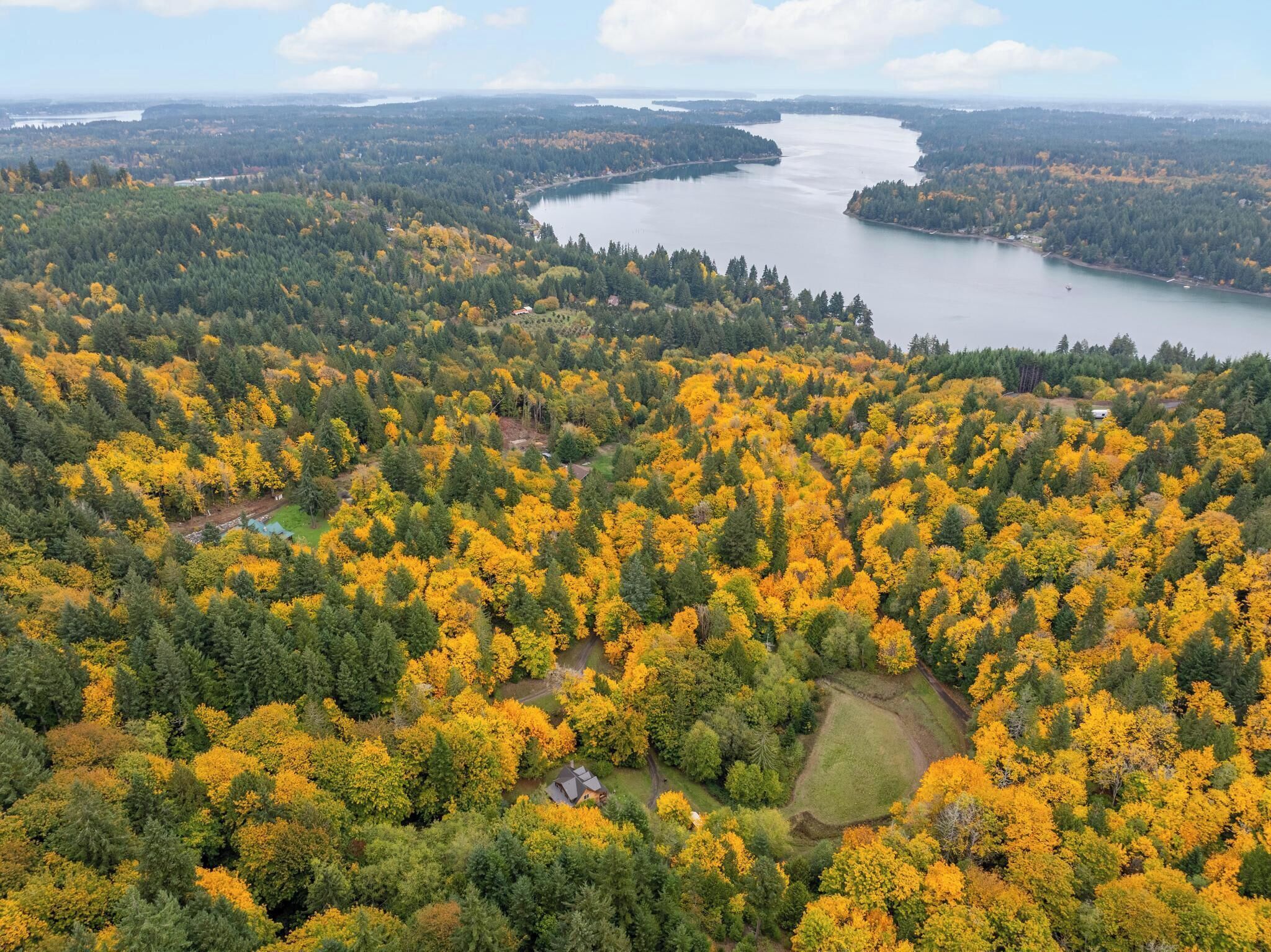 Ilmakuva metsäisestä alueesta, jossa on järvi ja pieni asutuskeskus.