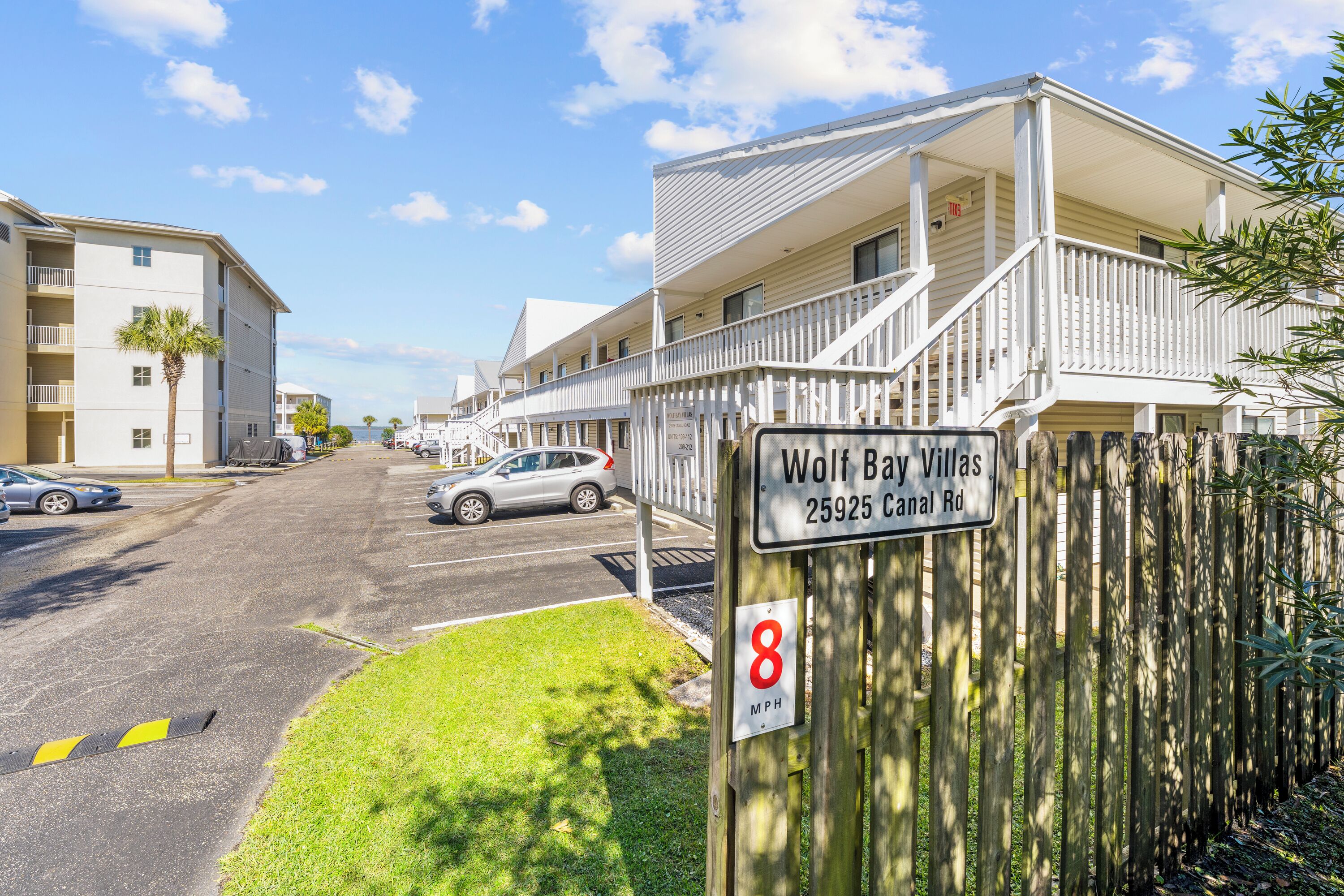 A residential area with a sign for Wolf Bay Villas at 25925 Canal Rd.