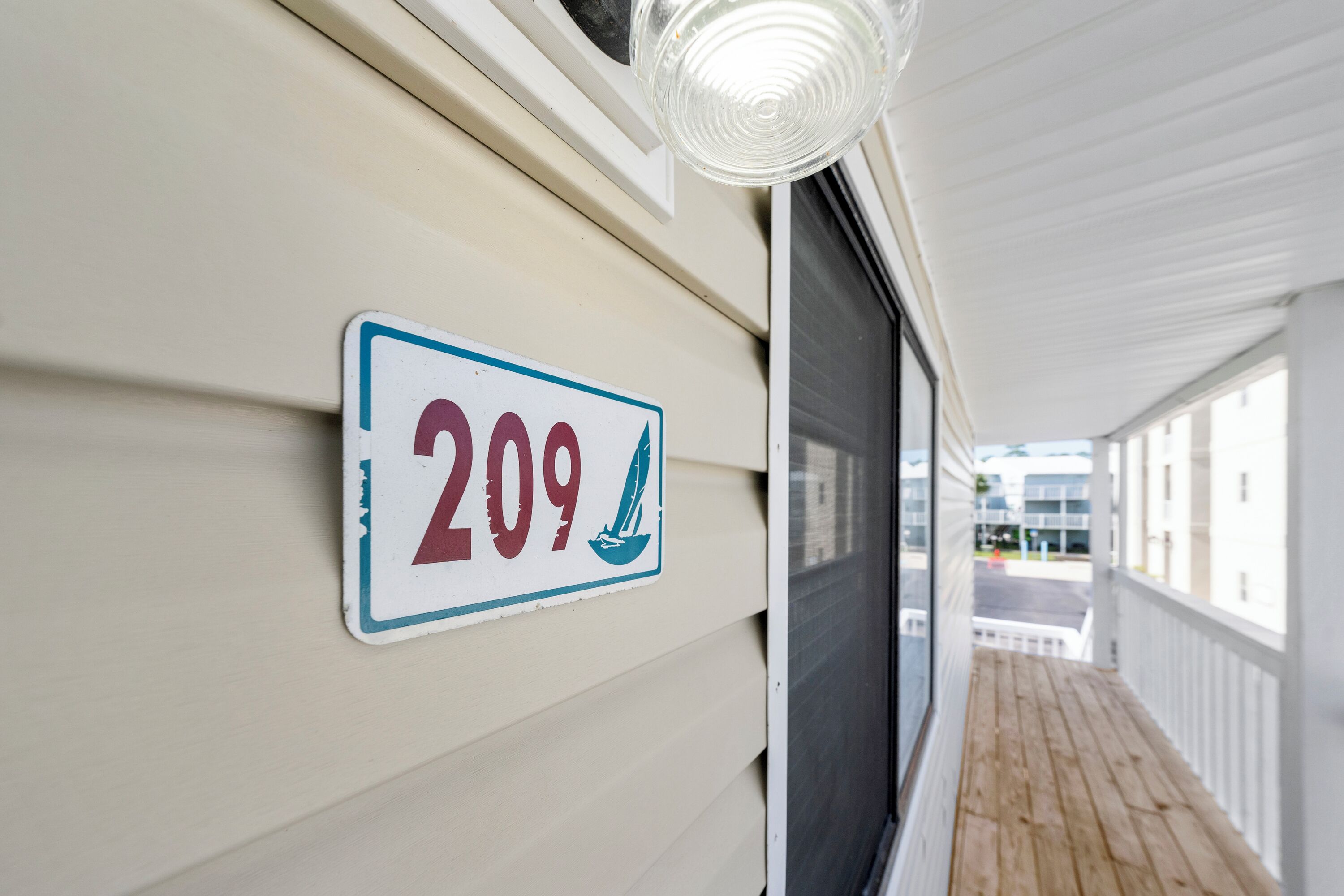 Un cartello con il numero 209 affisso sulla parete esterna di un edificio, che indica un numero civico o unità.