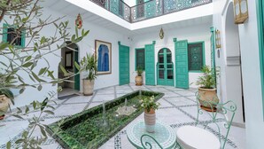 A courtyard with a fountain, potted plants, and a tiled floor. - Riad Nejma BenYoussef (Marrakech)
