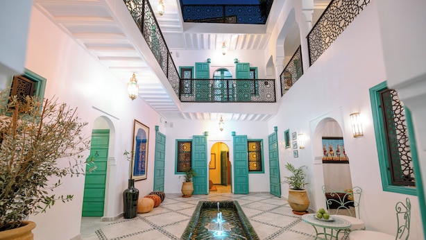 A spacious interior with a central fountain, green doors, and a balcony with intricate lattice work. - Riad Nejma BenYoussef (Marrakech)