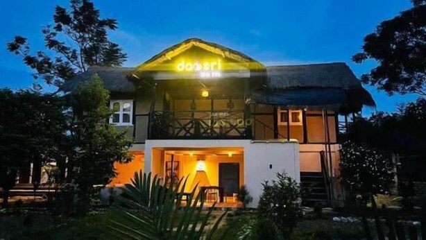 A two-story building with a thatched roof and a neon sign reading "daosri." - Daosri The Inn (Barangabari)