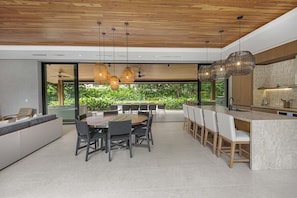 Una cocina moderna con una isla grande, techo de madera e iluminación colgante.