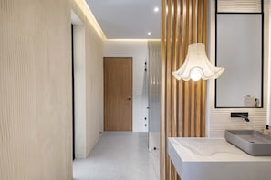 Un bany modern amb un mirall gran, un lavabo i una zona de dutxa.