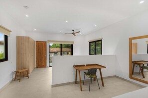 Ein modernes Interieur mit einem Holztisch, einem Stuhl und einem Deckenventilator.