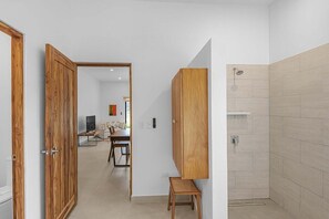 A modern bathroom with a shower, a wooden cabinet, and a small stool. - Casa Campana (Santa Cruz)