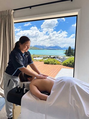 A massage therapy session in a room with a large window overlooking a scenic landscape. - Blue Sky | Lake Views + Private Deck + Stargazing (Lake Tekapo)