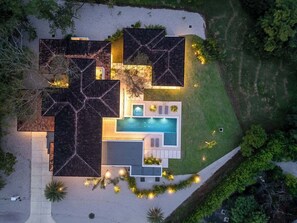 Ein modernes Haus mit Schwimmbad, mehreren Zimmern und einem gepflegten Garten.